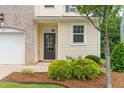 Close up of a townhome with brick, siding and a mulched garden surrounding the front entrance at 1007 Epiphany Rd, Morrisville, NC 27560