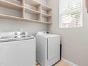 Bright laundry room with modern appliances, shelving, and a window for natural light at 1007 Epiphany Rd, Morrisville, NC 27560