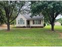 Quaint single-story home with symmetrical design, mature trees, and lush lawn for a serene curb appeal at 101 New Castle Ct, Youngsville, NC 27596