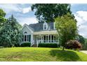 Inviting home with a charming front porch, surrounded by lush greenery and mature trees at 101 Stefi Ct, Garner, NC 27529