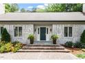 Inviting front entrance with brick steps, potted plants and a charming blue front door at 1023 Cleland Dr, Chapel Hill, NC 27517