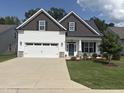 Charming home featuring white siding, stone accents, a two-car garage, and a well-manicured lawn at 108 Sweetbay Park, Youngsville, NC 27596
