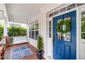Inviting porch showcasing a swing, blue front door with wreath, and a decorative rug and plant at 10847 Bedfordtown Dr, Raleigh, NC 27614