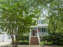 Inviting two-story home with a front porch, brick steps, and an American flag adding charm at 10859 Bedfordtown Dr, Raleigh, NC 27614
