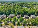 High aerial view of a residential neighborhood with lush green trees and well-maintained homes at 109 Aspenridge Dr, Holly Springs, NC 27540