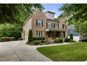 Elegant brick home featuring a lush lawn, manicured landscaping, a curved driveway, and an attached garage at 109 Aspenridge Dr, Holly Springs, NC 27540
