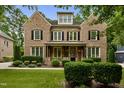Charming two-story brick home with a beautifully landscaped front yard and a welcoming front porch at 109 Aspenridge Dr, Holly Springs, NC 27540