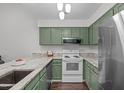 Cozy kitchen featuring green cabinets, granite countertops, and stainless steel appliances at 11 Stone Village Ct, Durham, NC 27704