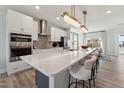 Kitchen boasts white cabinets, stainless appliances, an island with seating, and modern pendant lights at 1230 Coach Station Alley # 201, Raleigh, NC 27601