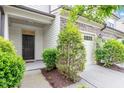 Entrance view of a townhome featuring well maintained landscaping, covered entrance, and a two car garage at 140 Token House Rd, Durham, NC 27703