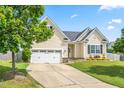 Attractive single-Gathering home featuring an attached two-car garage, driveway, and lush green lawn at 1400 Manley Ct, Fuquay Varina, NC 27526