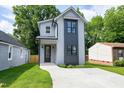 Charming two-story home featuring modern architectural design, concrete driveway, and well-maintained lawn at 1410 Joe Louis Ave, Raleigh, NC 27610