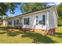 Inviting single-story home with a small front porch, vinyl siding, and lush green lawn at 1442 Morningside Dr, Burlington, NC 27217