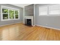 Spacious living room boasting a decorative fireplace with a wood accent wall, hardwood floors, and bright windows at 1521 N Duke St, Durham, NC 27701