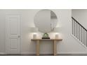 Inviting entryway with wooden console table, round mirror, and stairway with iron spindles at 172 Paramount Dr, Smithfield, NC 27577