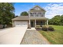 Charming two-story home featuring a brick and siding facade, attached garage, and a well-maintained front yard at 2021 W Front St, Burlington, NC 27215
