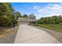 Charming two-story home featuring a brick and siding facade, attached garage, and a well-maintained front yard at 2021 W Front St, Burlington, NC 27215