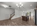 Open-concept living room with wood floors, stairs, and kitchen island with granite counters at 2021 W Front St, Burlington, NC 27215
