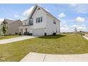 Two-story home with white siding, stone accents, covered porch, an attached two-car garage, and landscaped front yard at 218 Faith Avenue, Sanford, NC 27330