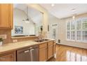 Kitchen with hardwood floors and stainless dishwasher overlooking a living area at 2311 Woodwyck Way, Raleigh, NC 27604