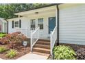 Close-up of the home's entrance, showing the white railing and brick steps leading up to the blue front door at 2324 Hoskins Rd, Burlington, NC 27215