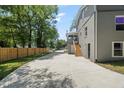 Long driveway leading to a gray two-story home with a backyard fence and a stairway to a screened-in porch at 2617 Fayetteville St, Durham, NC 27707