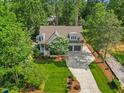 Aerial view of home with a lush lawn, mature trees, and long driveway at 3034 Lewis Farm Rd, Raleigh, NC 27607