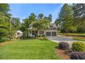 Inviting home exterior with a lush lawn, mature tree, and ample driveway space at 3034 Lewis Farm Rd, Raleigh, NC 27607