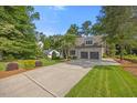 Beautiful home exterior with an expansive driveway and lush landscaping in a serene setting at 3034 Lewis Farm Rd, Raleigh, NC 27607