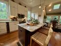 Eat-in kitchen featuring white cabinets, granite counters, stainless steel appliances, and breakfast bar seating at 313 W Noble St, Louisburg, NC 27549