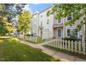 Townhouses with fenced-in front yards, landscaping, and trees at 330 Gilman Ln # 109, Raleigh, NC 27610