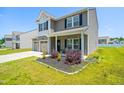 Beautiful home with a well-maintained lawn, two-car garage, and covered front porch at 341 Henry Steel Dr, Gibsonville, NC 27249