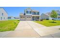 Charming two-story home featuring a two-car garage, well-manicured lawn, and inviting front porch at 341 Henry Steel Dr, Gibsonville, NC 27249