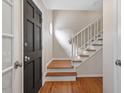 Bright entryway featuring hardwood floors and a classic staircase at 3705 Old Post Rd, Raleigh, NC 27612