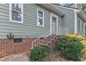 Close-up of the front exterior featuring brick foundation, shrubbery, steps and white rails to enter the home at 410 Oak Run Dr, Raleigh, NC 27606