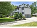 A view of the side of the house and the garages with landscaping at 4217 Grahamstone Rd, Raleigh, NC 27610