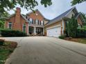 View of a brick home with an attached two-car garage and well-manicured landscaping at 502 Willowmere Ct, Cary, NC 27513