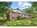 Two-story brick home with manicured lawn and mature trees, offering classic charm and curb appeal at 5414 Ventoria Rd, Durham, NC 27712