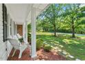 Inviting front porch with comfortable seating, offering a relaxing view of the landscaped yard at 5414 Ventoria Rd, Durham, NC 27712