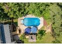 Aerial view of a private backyard oasis, including a pool with umbrellas and a cabana at 5712 Turner Store Ln, Raleigh, NC 27603