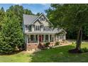 Beautiful two-story home with a red front door, complemented by a covered porch and lush greenery at 5712 Turner Store Ln, Raleigh, NC 27603