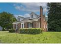 Angle shot of lovely brick house showing manicured bushes, dormers, chimney, and a well-kept lawn at 631 Park Ave, Rocky Mount, NC 27801