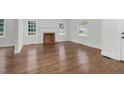 Open-concept living area with hardwood floors and fireplace, bathed in natural light from large windows at 631 Park Ave, Rocky Mount, NC 27801