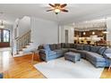 Bright living room with hardwood floors, ceiling fan, and staircase to the second floor at 7906 Longleaf Branch Ct, Raleigh, NC 27612