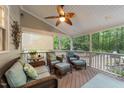 Relaxing back porch featuring comfortable seating, a ceiling fan, and views of the wooded backyard at 8004 Gabriels Bend Dr, Raleigh, NC 27612