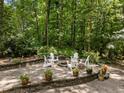 Outdoor patio with a fire pit, surrounded by chairs, flowers and beautiful landscaping at 8004 Gabriels Bend Dr, Raleigh, NC 27612