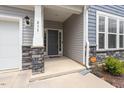 Inviting front porch features stone accents and a stylish front door with house numbers at 815 Harmony Ranch Ln, Franklinton, NC 27525