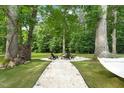Relaxing backyard with a stone firepit area, hammock, and mature trees providing shade and privacy at 947 Weatherby Ln, Creedmoor, NC 27522