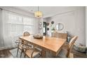 Bright dining room featuring a large table, modern light fixture, and a view of the front entrance at 947 Weatherby Ln, Creedmoor, NC 27522