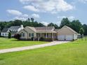 Spacious front lawn and long driveway leading to a tan home with an attached two-car garage at 110 Westlake Dr, Wendell, NC 27591